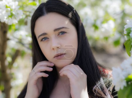 Téléchargez les photos : Portrait d'une jeune femme parmi les fleurs de cerisier. - en image libre de droit
