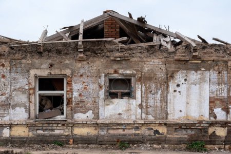 Téléchargez les photos : Détruit et brûlé des maisons dans la ville pendant la guerre en Ukraine - en image libre de droit