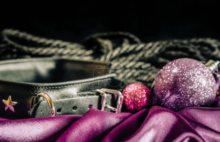 Téléchargez les photos : Bdsm nature morte collier en cuir noir shibari corde et lilas boule de Noël sur tissu rose gros plan - en image libre de droit