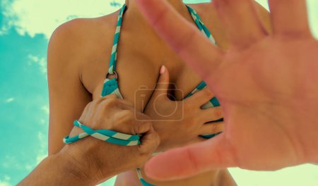 Foto de Acoso sexual mano masculina tratar de arrancar sujetador de pecho femenino - Imagen libre de derechos