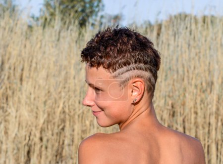 Foto de Chica joven con la piel bronceada con un corte de pelo undercut y tiras afeitadas en la cabeza - Imagen libre de derechos