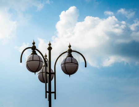 Téléchargez les photos : Lampadaire contre un ciel bleu et des nuages blancs - en image libre de droit