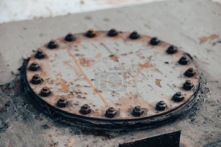Photo for Iron manhole closed with many bolts industrial background gas and oil production - Royalty Free Image