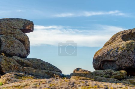 large stones against a blue sky and white clouds