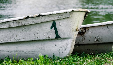 vieux bateau numéro un sur la rive de la rivière sur l'herbe verte sans personnes