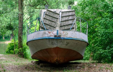 vieux bateau sur la rive de la rivière sur l'herbe verte sans personnes