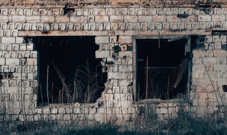 leere Fenster eines beschädigten Hauses Krieg in der Ukraine