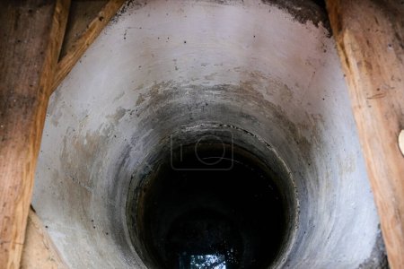 Foto de Vista a un pozo excavado a mano con anillos de hormigón. Mosquitos escondidos en el pozo de hormigón. Lago Svitiaz, Parque Nacional Natural de Shatsk, Ucrania. Copiar espacio. - Imagen libre de derechos