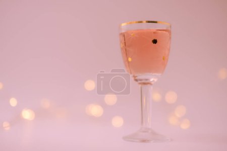 Foto de Vino rosa en una copa de estrella vintage. Bokeh. Fondo rojo violeta pálido. Copiar espacio. Profundidad superficial del campo. - Imagen libre de derechos