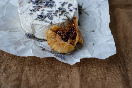 Photo for Dry fig, Camembert cheese, dry lavender. Brown linen tablecloth. Copy space. - Royalty Free Image