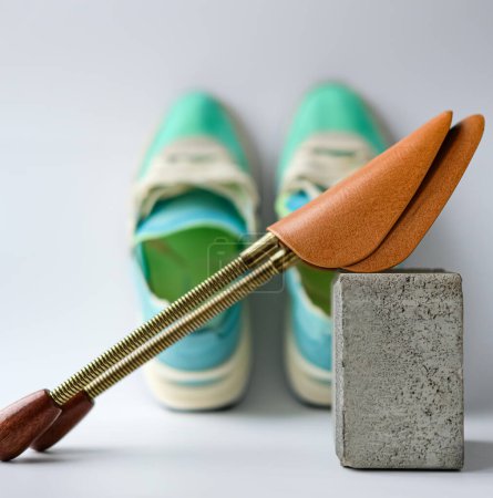 Metal Shoe Shape Holder sobre un fondo borroso de las zapatillas Aqua y Lime Color. Profundidad de campo superficial.