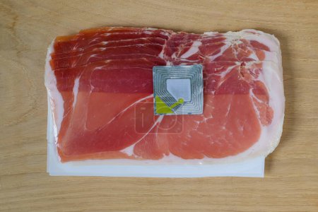 The used security tag or radio frequency security label is on the Spanish ham. Cutting board.