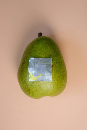 The used security tag or radio frequency security label is on the green pear. Anti-theft labels.
