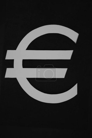 Euro currency sign. White paper cut symbol. Black background.