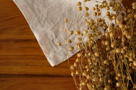 Flax seeds pods. Linen fabric. Wooden background. Copy space.