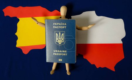 Maniquí humano de madera con pasaporte ucraniano. Mapa de Polonia. Mapa de España. Fondo azul de la bandera de la Unión Europea. Ucrania migración de población. Guerra. La amenaza de la vida.
