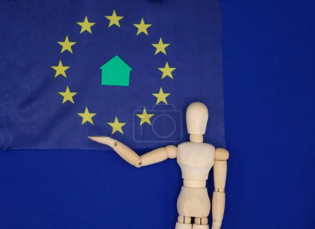 El modelo de lo humano muestra la bandera de la Unión Europea. Green Home. Acuerdo Verde Europeo. Normativa medioambiental.