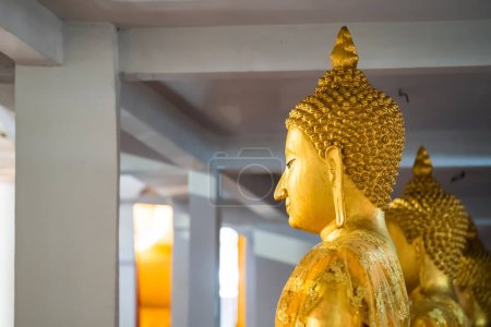 Foto de Una gran cantidad de estatua de oro de Buda sentado meditó en la fila en el templo de Tailandia. - Imagen libre de derechos