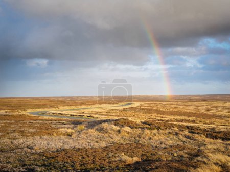 Foto de Arcos de arco iris sobre la sinuosa carretera y páramos bajo el cielo sombrío y nubes oscuras en la cabecera del valle del Rosedale, Parque Nacional de North York Moors, Reino Unido - Imagen libre de derechos
