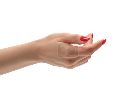 Foto de Primer plano de la mano femenina con la piel pálida y las uñas rojas apuntando o tocando aislado sobre un fondo blanco. - Imagen libre de derechos