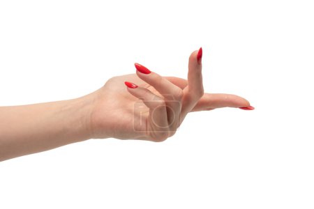 Foto de Primer plano de la mano femenina con la piel pálida y las uñas rojas apuntando o tocando aislado sobre un fondo blanco. - Imagen libre de derechos