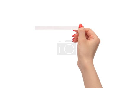 Foto de Mano de mujer con uñas rojas con tiras de prueba para el perfume, aislada sobre un fondo blanco. Bloqueadores de perfume. - Imagen libre de derechos