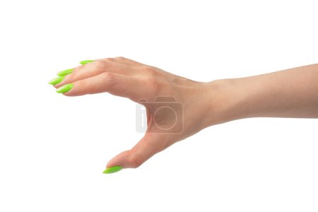 Foto de Mano de una mujer con naols verdes sostiene algún objeto minúsculo o delgado, aislado sobre un fondo blanco. - Imagen libre de derechos