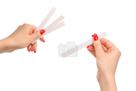 Téléchargez les photos : Main de femme avec des ongles rouges avec des bandes d'essai pour le parfum, isolé sur un fond blanc. Boutons de parfum. - en image libre de droit