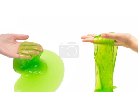 Grünes Schleimspielzeug in Frauenhand isoliert auf weißem Grund.