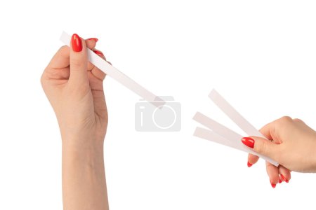 Frauenhand mit roten Nägeln mit Teststreifen für das Parfüm, isoliert auf weißem Hintergrund. Parfümdiebe.