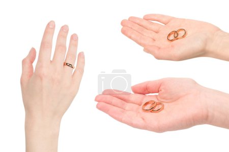 Deux anneaux dorés dans une main de femme isolée sur un fond blanc. Concept de mariage. 