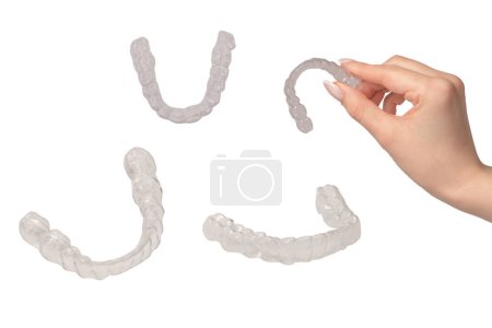 Transparent mouth guard in a woman's hand isolated on a white background. 