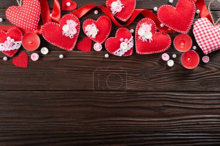 Foto de Costura hechos a mano corazones de tela y velas de aroma para el día de San Valentín sobre fondo de madera oscura con espacio de copia - Imagen libre de derechos