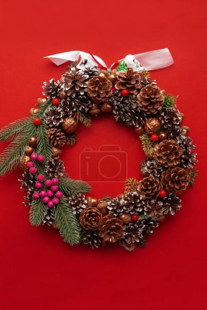 Photo for Christmas decoration with pine cones, decorated christmas wreath on red background.  Christmas mood - Royalty Free Image