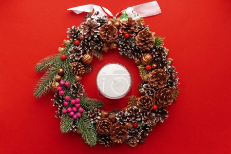 Téléchargez les photos : Décoration de Noël avec cônes de pin, couronne de Noël décorée sur fond rouge. humeur de Noël - en image libre de droit