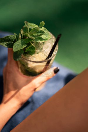 Foto de Coctel refrescante de menta de verano mojito con ron y hielo en vidrio sobre fondo negro - Imagen libre de derechos