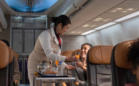 Stewardess oder Kabinenpersonal im Flugzeug. Flugbegleiterin serviert Geschäftsfrau an Bord Orangensaft Konzept für Luftverkehr und Tourismus.