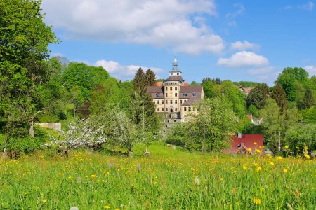 Photo for Zittau Mountains, the Hainewalde palace in spring with apple trees in blossom - Royalty Free Image