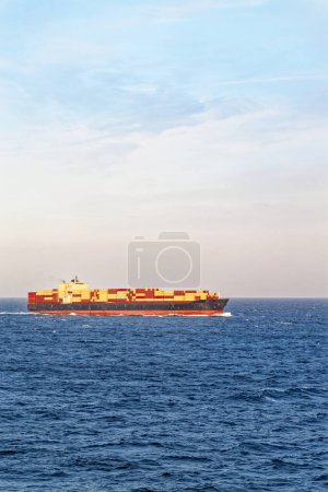 Szenischer Blick auf großes Fracht-Containerschiff, das an sonnigen Tagen auf offener See fährt