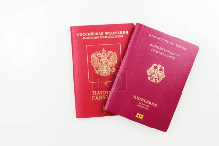 Russischer Originalpass hinter deutschem Pass isoliert auf weißem Hintergrund