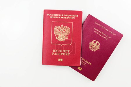 Original deutscher Pass hinter russischem Pass isoliert auf weißem Hintergrund