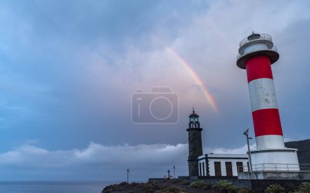 Foto de Faros viejos y nuevos bajo el arco iris y nubes tormentosas - Imagen libre de derechos