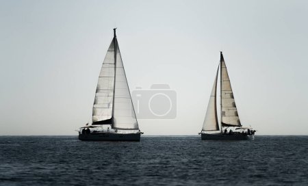 Photo for Two sailing ships crossing course in the ocean against white sky - Royalty Free Image