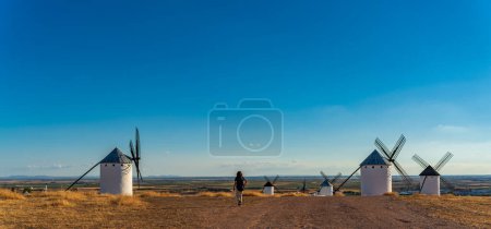 Téléchargez les photos : Vue arrière d'un touriste méconnaissable entrant dans le réseau des moulins à vent avec espace texte - en image libre de droit