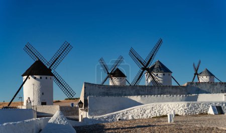Foto de Old windmills array under clear blue sky for text - Imagen libre de derechos