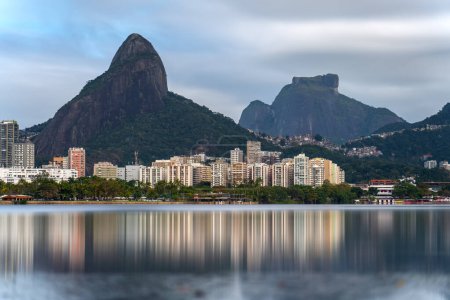 Foto de Larga exposición de Río de Janeiros Lagoa con edificios residenciales, Rosinha favela, y Dos Hermanos y Pedra da Gavea rocas. - Imagen libre de derechos