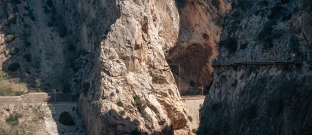 Photo for Scenic view of Caminito del Rey with tourists on walkways and a train passing through the canyon in Malaga. - Royalty Free Image