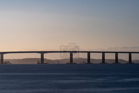 Photo for Long exposure shot of a bridge over calm waters at sunset, symbolizing connection. - Royalty Free Image