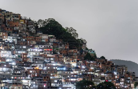 Téléchargez les photos : Favela de colline densément emballée illuminée la nuit. - en image libre de droit