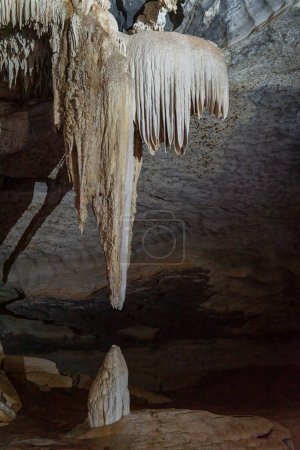 Téléchargez les photos : Des structures calcaires dans une grotte sombre créent une scène mystérieuse. - en image libre de droit